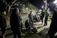 Terduga pelaku saat diamankan polisi dari amukan warga.