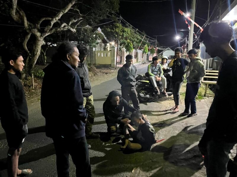 Terduga pelaku saat diamankan polisi dari amukan warga.